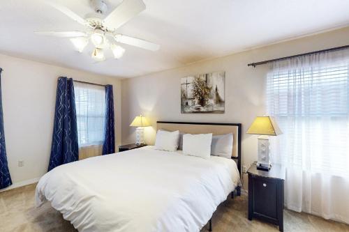 德斯坦的住宿－Sun Sailing，卧室配有白色的床和吊扇