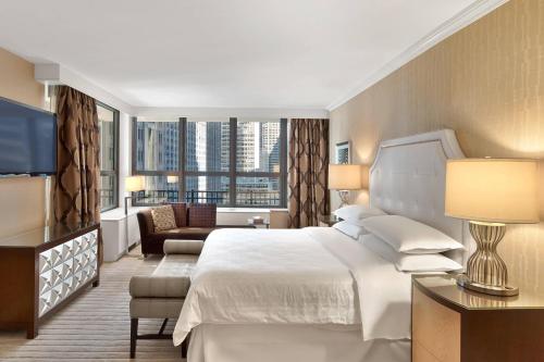 um quarto de hotel com uma cama e uma grande janela em Sheraton New York Times Square Hotel em Nova York