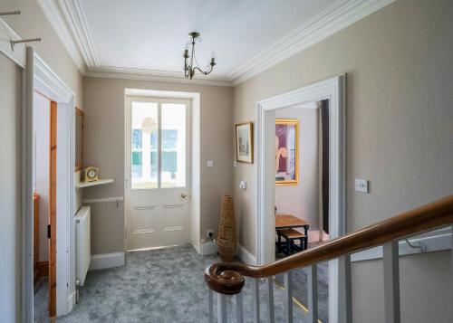 a hallway of a home with a staircase and a door at Gledfield Highland Estate in Culrain