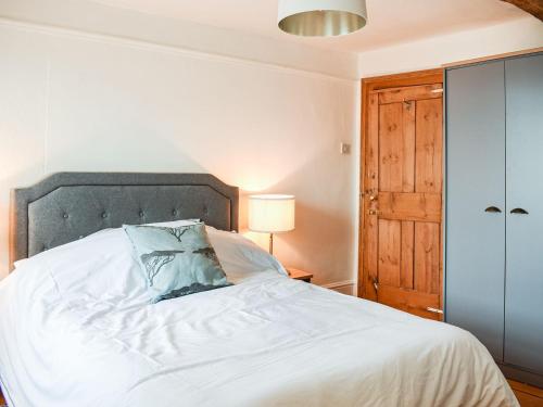 a bedroom with a white bed with a blue pillow at Market Place View in Knaresborough