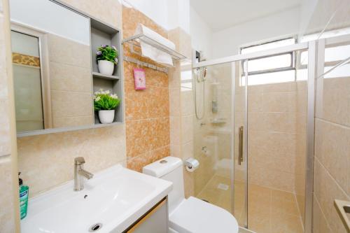 a bathroom with a shower and a toilet and a sink at Lux Suites Sandalwood Furnished Apartments in Nairobi