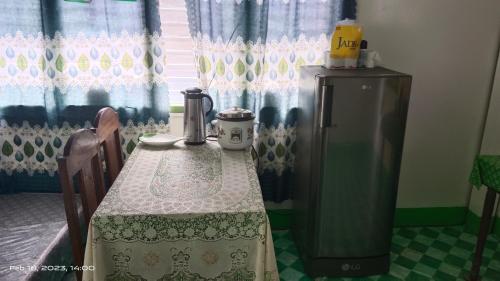 a kitchen with a table with a refrigerator and a window at Ustaris Homestay in Itaytay