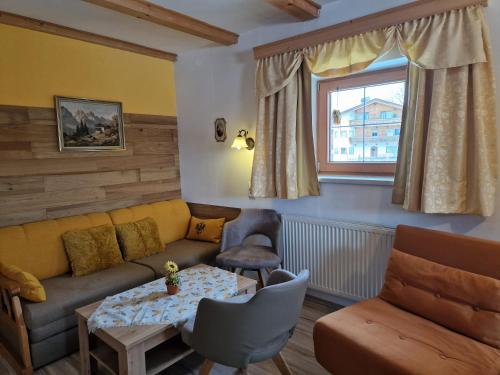 a living room with a couch and a table at Badhaus in Achenkirch