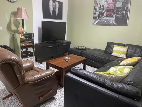 Sala de estar con 2 sofás y TV en The Gulch Apartments en Bonabéri