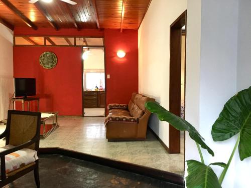 sala de estar con sofá y paredes rojas en Casa de Tigres en Tigre