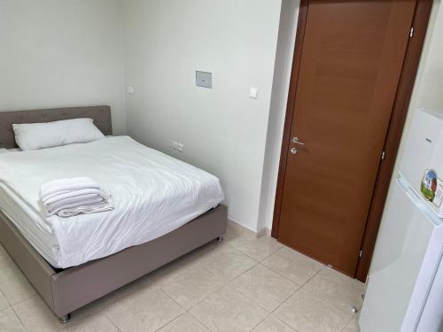 ein kleines Schlafzimmer mit einem Bett und einer braunen Tür in der Unterkunft Studio with Sun Terrace - 1 in Bat Yam