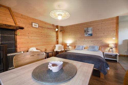 a room with two beds and two tables in it at Le Gite de Noemie in Mercury