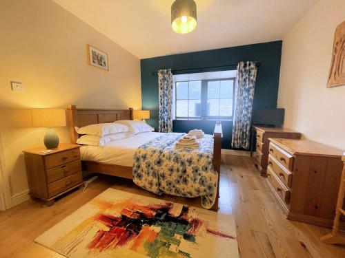 a bedroom with a bed and a dresser and a window at Beautiful Rural 3BR Cottage with Stunning Views in Auldgirth