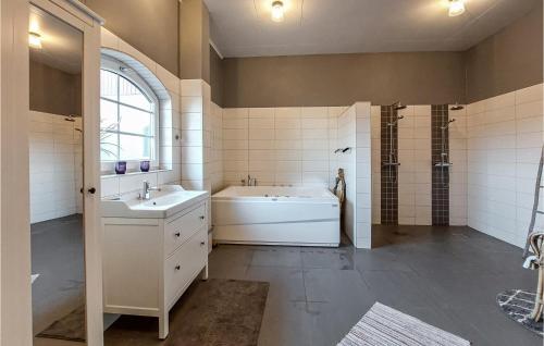 ein Bad mit einer Badewanne, einem Waschbecken und einer Dusche in der Unterkunft Nice Home In Ljungbyhed With Kitchen in Ljungbyhed