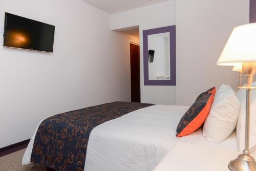 Una cama o camas en una habitación de Santiago Hotel