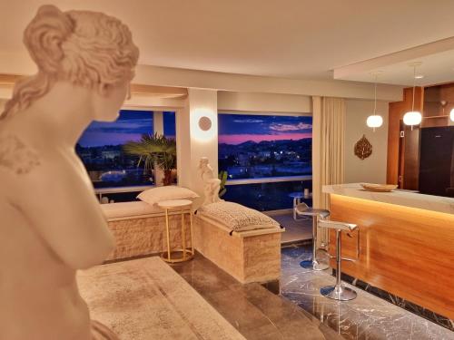 una statua di una donna in piedi in una stanza con una camera da letto di One 360 Skyline Athens Penthouses ad Atene