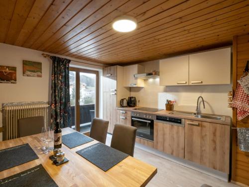 a kitchen with a table with chairs and a kitchen with at Haus Spertental in Kirchberg in Tirol