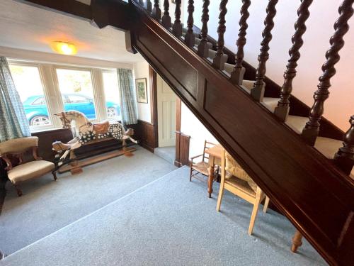 a staircase in a living room with a stair case at Beautiful 4BR Period Home With Spectacular Views in Kippford