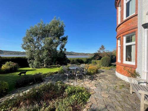 a patio with a table and chairs next to a building at Beautiful 4BR Period Home With Spectacular Views in Kippford