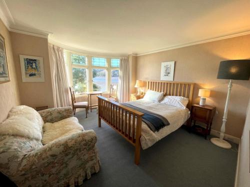a bedroom with a bed and a couch and a chair at Beautiful 4BR Period Home With Spectacular Views in Kippford