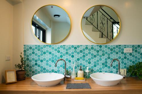 a bathroom with two sinks and two mirrors at Lixia Hostel in Xiaoliuqiu