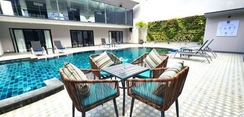 a patio with a table and chairs next to a swimming pool at Amalthea Hotel in Patong Beach