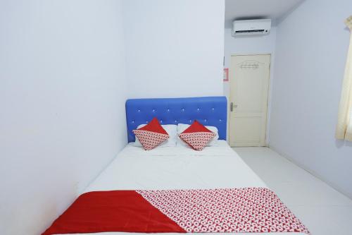 a bedroom with a bed with red and white pillows at OYO 92261 Aulia Homestay Syariah in Bagam