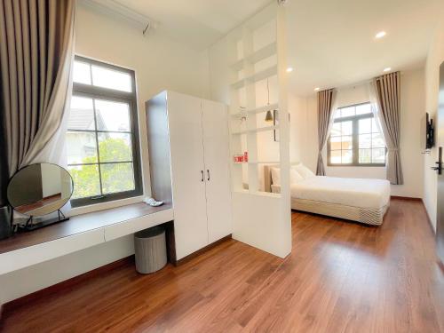 a room with a bedroom with a bed and a window at Camellia Villa Hotel in Khu Chi Lăng