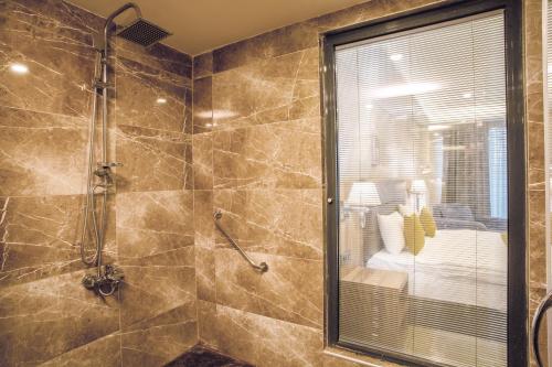 uma casa de banho com um chuveiro e uma porta de vidro em Royal Termal Hotel em Bursa