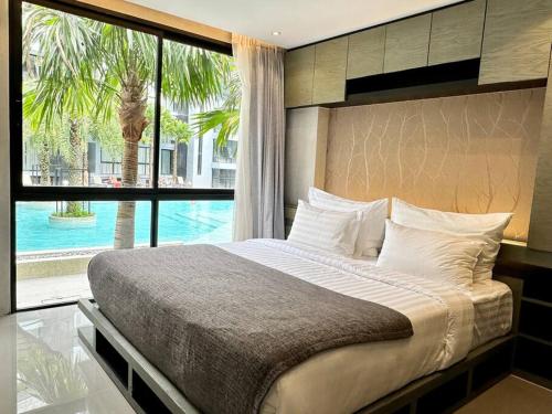 a bedroom with a large bed and a large window at Kamala Beach Pool view Resort P15 in Kamala Beach