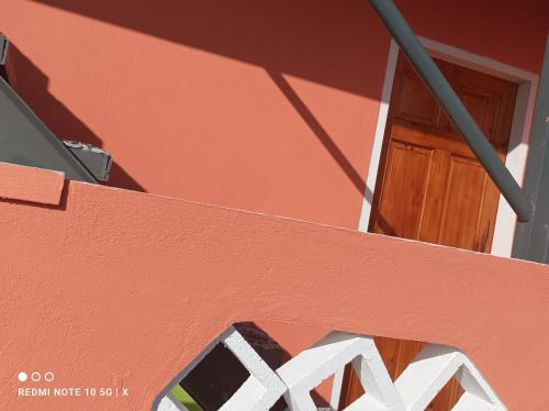 un edificio rojo con puerta y ventana en Excellent Pleasantville Apartment, en San Fernando