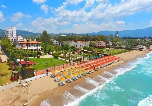 een luchtzicht op een strand met parasols en de oceaan bij Sentinus Beach Hotel in Kuşadası