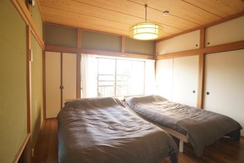 ein großes Bett in einem Zimmer mit einem großen Fenster in der Unterkunft 海テラス伊豆高原Ａ in Yawatano