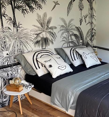 - une chambre avec un lit orné d'une fresque murale de palmiers dans l'établissement LaCabane, à Cormondreche