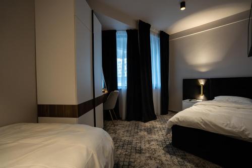 a hotel room with two beds and a window at Hotel Cristal in Cluj-Napoca