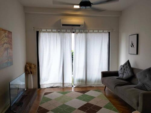 - un salon avec un canapé et une grande fenêtre dans l'établissement RDR Homestay@Emira Residence, à Shah Alam