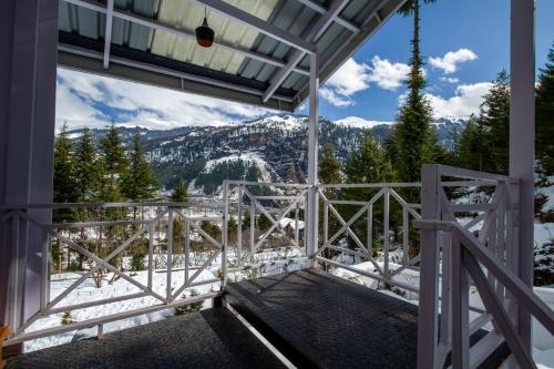 a balcony with a view of the mountains at Baan by Snow City Farm in Vashisht