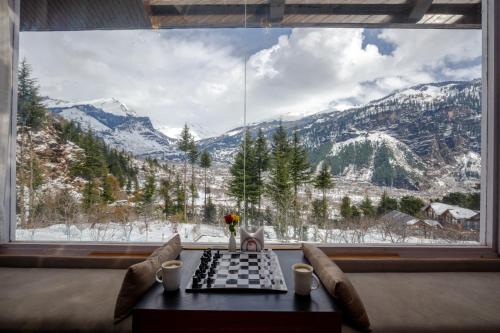a table in a room with a view of a mountain at Baan by Snow City Farm in Vashisht