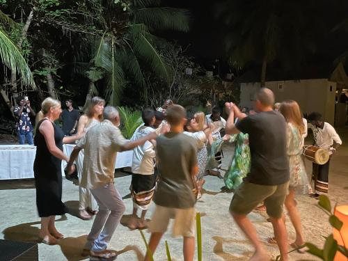 a group of people dancing at a party at Three Hearts Guesthouse and Villas in Fulhadhoo