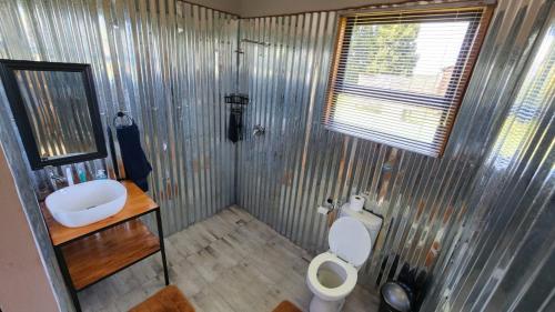 a small bathroom with a toilet and a sink at Amperda Log Cabins in Bergheim