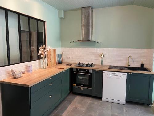 une cuisine avec des placards verts et un comptoir dans l'établissement Villa soulac 6 chambres, wifi, à Soulac-sur-Mer