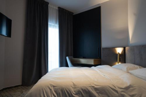 a bedroom with a large white bed and a window at Hotel Cristal in Cluj-Napoca
