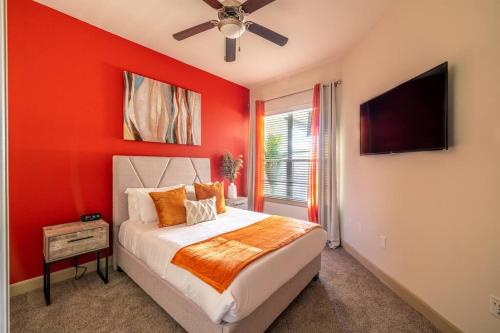 a red bedroom with a bed and a flat screen tv at PackHouse 2 in Houston