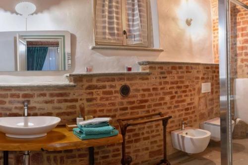 a bathroom with a sink and a toilet and a mirror at appartamento mamasita in Andezeno