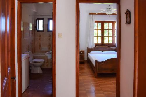 a bathroom with a bedroom with a bed and a tub at Apartment in a summer house close to the sea in Chorefto