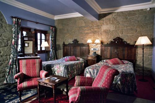 1 dormitorio con 2 camas, mesa y sillas en Hotel Castillo El Collado, en Laguardia
