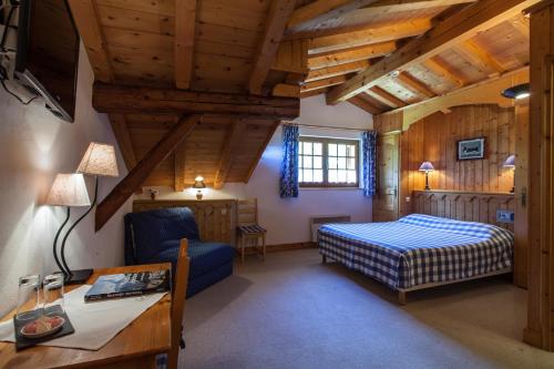 un dormitorio con una cama y un escritorio en una habitación en le Montagny, en Les Houches