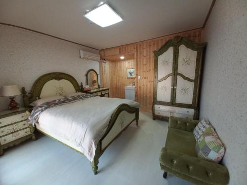 um quarto com uma cama, uma cadeira e um espelho em Wolyeongchae em Andong