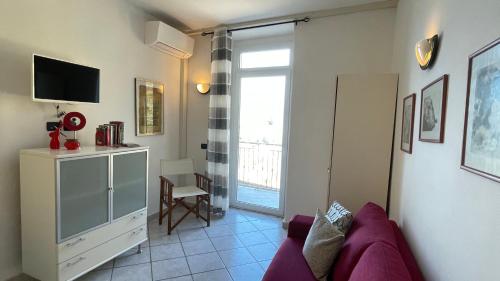 a living room with a purple couch and a tv at Casa Vacanze Da Paulin in Manarola