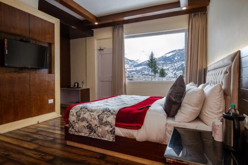 ein Schlafzimmer mit einem Bett und einem großen Fenster in der Unterkunft Baan by Snow City Farm in Vashisht