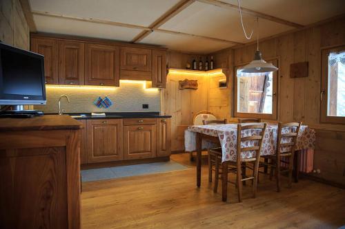 cocina con mesa y sillas y TV en Casa Smitt, en Alagna Valsesia