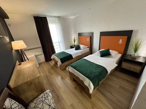 a hotel room with two beds in a room at Business Hotel Prijedor in Prijedor