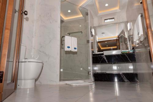 a bathroom with a toilet and a shower and a sink at Palma Beach Resort & Spa in Umm Al Quwain