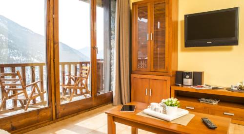 a living room with a television and a balcony at Appartement Ona Dorada el Tarter in Ransol