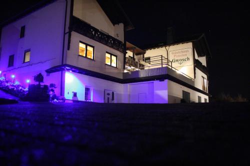 Ferienwohnung Moselpension Gwosch في بروتيج-فانكيل: مبنى به أضواء أرجوانية في الليل